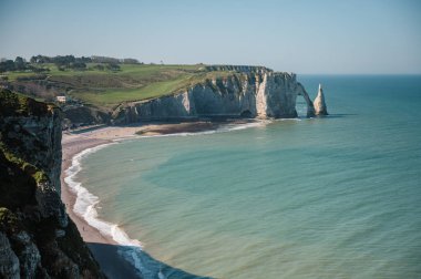 Etretat 'ın ikonik tebeşir kayalıkları ve turkuaz suları güneş ışığı altında parlayarak Normandiya' nın doğal güzelliğini ve huzurlu sahil şeridini gözler önüne seriyor..