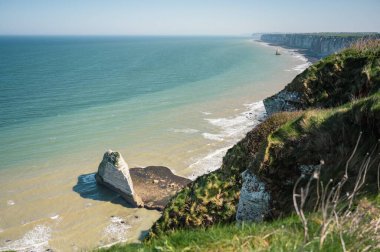 Etretat 'ın ikonik tebeşir kayalıkları ve turkuaz suları güneş ışığı altında parlayarak Normandiya' nın doğal güzelliğini ve huzurlu sahil şeridini gözler önüne seriyor..