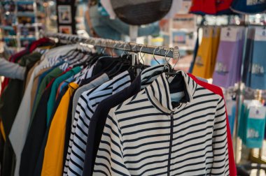 İkonik Breton tarzı çizgili tişört yerel bir butikte ahşap bir askıda asılı, zamansız Fransız modasını çağrıştırıyor..