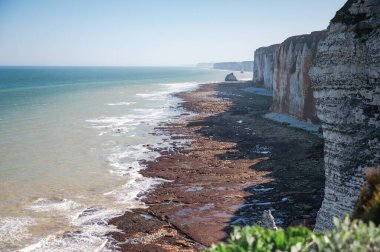Etretat 'ın ikonik tebeşir kayalıkları ve turkuaz suları güneş ışığı altında parlayarak Normandiya' nın doğal güzelliğini ve huzurlu sahil şeridini gözler önüne seriyor..