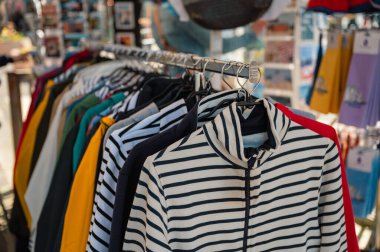 İkonik Breton tarzı çizgili tişört yerel bir butikte ahşap bir askıda asılı, zamansız Fransız modasını çağrıştırıyor..