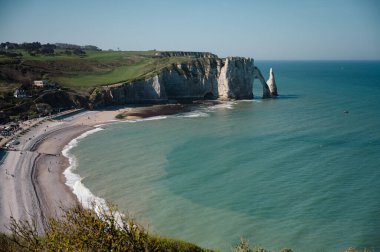 Etretat 'ın ikonik tebeşir kayalıkları ve turkuaz suları güneş ışığı altında parlayarak Normandiya' nın doğal güzelliğini ve huzurlu sahil şeridini gözler önüne seriyor..