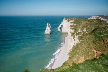 Etretat 'ın ikonik tebeşir kayalıkları ve turkuaz suları güneş ışığı altında parlayarak Normandiya' nın doğal güzelliğini ve huzurlu sahil şeridini gözler önüne seriyor..