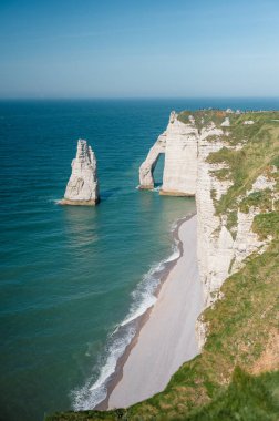 Etretat 'ın ikonik tebeşir kayalıkları ve turkuaz suları güneş ışığı altında parlayarak Normandiya' nın doğal güzelliğini ve huzurlu sahil şeridini gözler önüne seriyor..