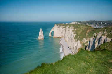 Etretat 'ın ikonik tebeşir kayalıkları ve turkuaz suları güneş ışığı altında parlayarak Normandiya' nın doğal güzelliğini ve huzurlu sahil şeridini gözler önüne seriyor..
