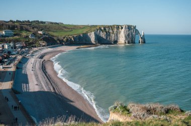 Etretat 'ın ikonik tebeşir kayalıkları ve turkuaz suları güneş ışığı altında parlayarak Normandiya' nın doğal güzelliğini ve huzurlu sahil şeridini gözler önüne seriyor..