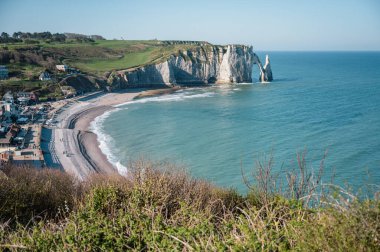 Etretat 'ın ikonik tebeşir kayalıkları ve turkuaz suları güneş ışığı altında parlayarak Normandiya' nın doğal güzelliğini ve huzurlu sahil şeridini gözler önüne seriyor..