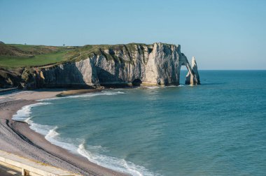 Etretat 'ın ikonik tebeşir kayalıkları ve turkuaz suları güneş ışığı altında parlayarak Normandiya' nın doğal güzelliğini ve huzurlu sahil şeridini gözler önüne seriyor..