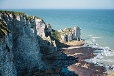 Etretat 'ın ikonik tebeşir kayalıkları ve turkuaz suları güneş ışığı altında parlayarak Normandiya' nın doğal güzelliğini ve huzurlu sahil şeridini gözler önüne seriyor..