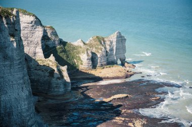 Etretat 'ın ikonik tebeşir kayalıkları ve turkuaz suları güneş ışığı altında parlayarak Normandiya' nın doğal güzelliğini ve huzurlu sahil şeridini gözler önüne seriyor..