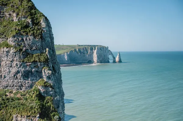 Etretat 'ın ikonik tebeşir kayalıkları ve turkuaz suları güneş ışığı altında parlayarak Normandiya' nın doğal güzelliğini ve huzurlu sahil şeridini gözler önüne seriyor..