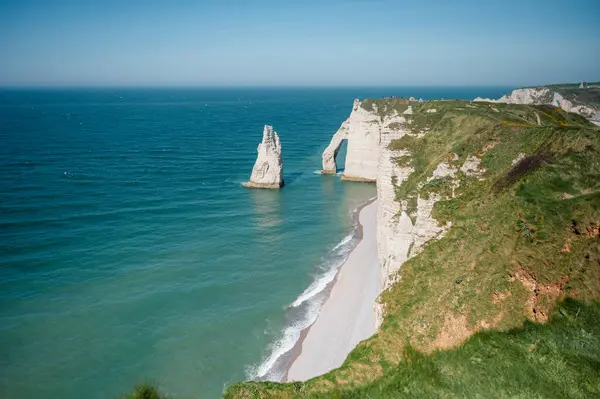 Etretat 'ın ikonik tebeşir kayalıkları ve turkuaz suları güneş ışığı altında parlayarak Normandiya' nın doğal güzelliğini ve huzurlu sahil şeridini gözler önüne seriyor..
