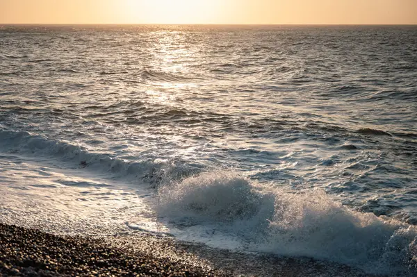 Etretat, Normandiya 'nın ikonik beyaz uçurumlarının yakınındaki turkuaz sulara güçlü bir dalga çarpar ve denizin saf güzelliğini gösterir..