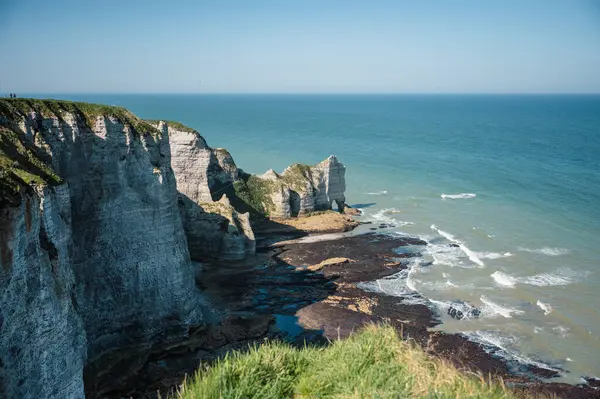 Etretat 'ın ikonik tebeşir kayalıkları ve turkuaz suları güneş ışığı altında parlayarak Normandiya' nın doğal güzelliğini ve huzurlu sahil şeridini gözler önüne seriyor..