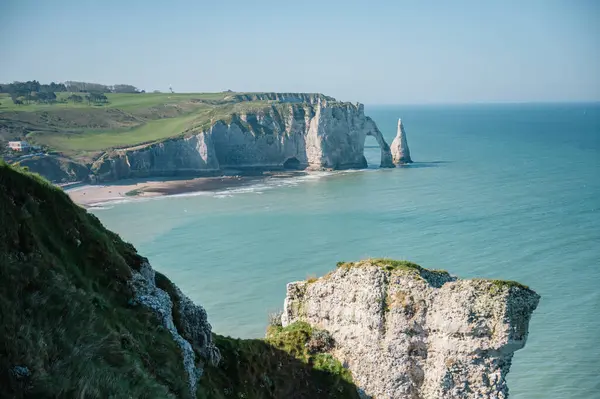 Etretat 'ın ikonik tebeşir kayalıkları ve turkuaz suları güneş ışığı altında parlayarak Normandiya' nın doğal güzelliğini ve huzurlu sahil şeridini gözler önüne seriyor..