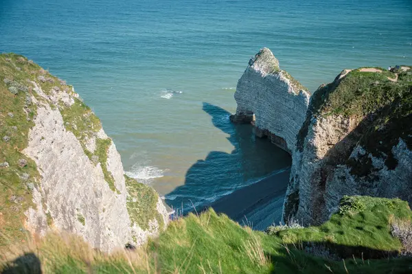 Etretat 'ın ikonik tebeşir kayalıkları ve turkuaz suları güneş ışığı altında parlayarak Normandiya' nın doğal güzelliğini ve huzurlu sahil şeridini gözler önüne seriyor..