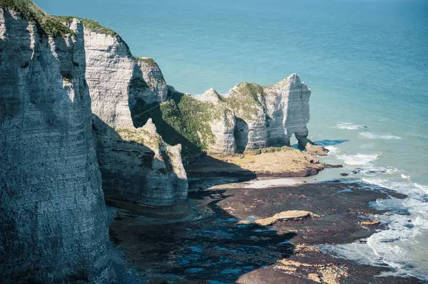 Etretat 'ın ikonik tebeşir kayalıkları ve turkuaz suları güneş ışığı altında parlayarak Normandiya' nın doğal güzelliğini ve huzurlu sahil şeridini gözler önüne seriyor..
