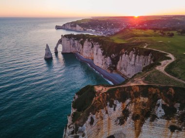 Etretat 'ın ikonik tebeşir kayalıkları ve turkuaz suları güneş ışığı altında parlayarak Normandiya' nın doğal güzelliğini ve huzurlu sahil şeridini gözler önüne seriyor..