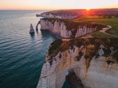 Etretat 'ın ikonik tebeşir kayalıkları ve turkuaz suları güneş ışığı altında parlayarak Normandiya' nın doğal güzelliğini ve huzurlu sahil şeridini gözler önüne seriyor..