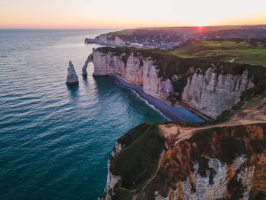 Etretat 'ın ikonik tebeşir kayalıkları ve turkuaz suları güneş ışığı altında parlayarak Normandiya' nın doğal güzelliğini ve huzurlu sahil şeridini gözler önüne seriyor..