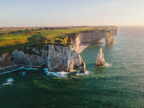 Etretat 'ın ikonik tebeşir kayalıkları ve turkuaz suları güneş ışığı altında parlayarak Normandiya' nın doğal güzelliğini ve huzurlu sahil şeridini gözler önüne seriyor..