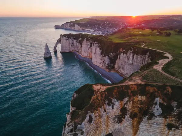 Etretat 'ın ikonik tebeşir kayalıkları ve turkuaz suları güneş ışığı altında parlayarak Normandiya' nın doğal güzelliğini ve huzurlu sahil şeridini gözler önüne seriyor..