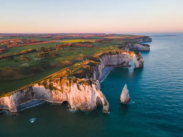 Etretat 'ın ikonik tebeşir kayalıkları ve turkuaz suları güneş ışığı altında parlayarak Normandiya' nın doğal güzelliğini ve huzurlu sahil şeridini gözler önüne seriyor..