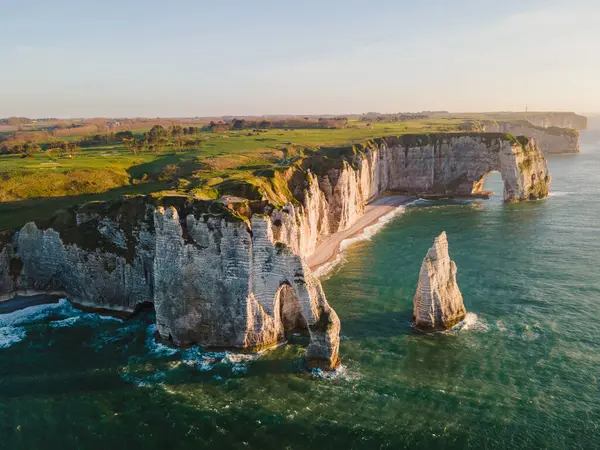 Etretat 'ın ikonik tebeşir kayalıkları ve turkuaz suları güneş ışığı altında parlayarak Normandiya' nın doğal güzelliğini ve huzurlu sahil şeridini gözler önüne seriyor..