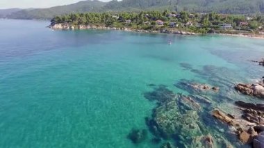 Yunanistan 'ın Chalkidiki kentindeki Karydi Sahili yakınlarındaki Sithonia kıyı şeridinin nefes kesici manzarası. Kristal berraklığında turkuaz sular engebeli kaya oluşumlarıyla birleşerek pitoresk bir Akdeniz cenneti yaratıyor..