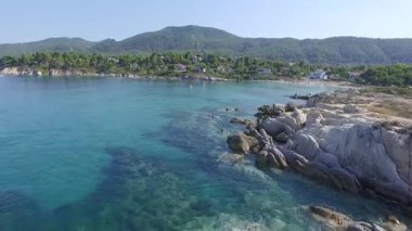 Yunanistan 'ın Chalkidiki kentindeki Karydi Sahili yakınlarındaki Sithonia kıyı şeridinin nefes kesici manzarası. Kristal berraklığında turkuaz sular engebeli kaya oluşumlarıyla birleşerek pitoresk bir Akdeniz cenneti yaratıyor..