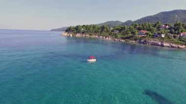 Yunanistan 'ın Chalkidiki kentindeki Karydi Sahili yakınlarındaki Sithonia kıyı şeridinin nefes kesici manzarası. Kristal berraklığında turkuaz sular engebeli kaya oluşumlarıyla birleşerek pitoresk bir Akdeniz cenneti yaratıyor..