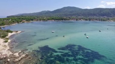Yunanistan 'ın Chalkidiki kentindeki Karydi Sahili yakınlarındaki Sithonia kıyı şeridinin nefes kesici manzarası. Kristal berraklığında turkuaz sular engebeli kaya oluşumlarıyla birleşerek pitoresk bir Akdeniz cenneti yaratıyor..