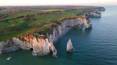 Etretat 'ın ikonik tebeşir kayalıkları ve turkuaz suları güneş ışığı altında parlayarak Normandiya' nın doğal güzelliğini ve huzurlu sahil şeridini gözler önüne seriyor..