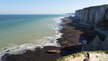 Etretat 'ın ikonik tebeşir kayalıkları ve turkuaz suları güneş ışığı altında parlayarak Normandiya' nın doğal güzelliğini ve huzurlu sahil şeridini gözler önüne seriyor..