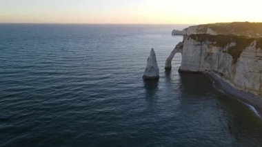 Etretat 'ın ikonik tebeşir kayalıkları ve turkuaz suları güneş ışığı altında parlayarak Normandiya' nın doğal güzelliğini ve huzurlu sahil şeridini gözler önüne seriyor..