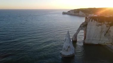 Etretat 'ın ikonik tebeşir kayalıkları ve turkuaz suları güneş ışığı altında parlayarak Normandiya' nın doğal güzelliğini ve huzurlu sahil şeridini gözler önüne seriyor..