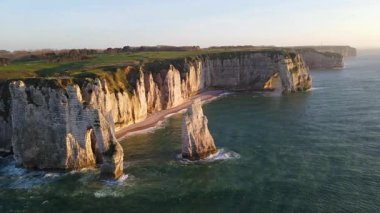 Etretat 'ın ikonik tebeşir kayalıkları ve turkuaz suları güneş ışığı altında parlayarak Normandiya' nın doğal güzelliğini ve huzurlu sahil şeridini gözler önüne seriyor..