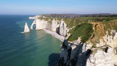 Etretat 'ın ikonik tebeşir kayalıkları ve turkuaz suları güneş ışığı altında parlayarak Normandiya' nın doğal güzelliğini ve huzurlu sahil şeridini gözler önüne seriyor..