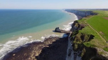 Etretat 'ın ikonik tebeşir kayalıkları ve turkuaz suları güneş ışığı altında parlayarak Normandiya' nın doğal güzelliğini ve huzurlu sahil şeridini gözler önüne seriyor..