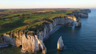 Etretat 'ın ikonik tebeşir kayalıkları ve turkuaz suları güneş ışığı altında parlayarak Normandiya' nın doğal güzelliğini ve huzurlu sahil şeridini gözler önüne seriyor..