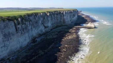 Etretat 'ın ikonik tebeşir kayalıkları ve turkuaz suları güneş ışığı altında parlayarak Normandiya' nın doğal güzelliğini ve huzurlu sahil şeridini gözler önüne seriyor..