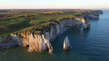 Etretat 'ın ikonik tebeşir kayalıkları ve turkuaz suları güneş ışığı altında parlayarak Normandiya' nın doğal güzelliğini ve huzurlu sahil şeridini gözler önüne seriyor..
