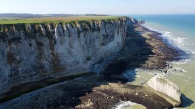 Etretat 'ın ikonik tebeşir kayalıkları ve turkuaz suları güneş ışığı altında parlayarak Normandiya' nın doğal güzelliğini ve huzurlu sahil şeridini gözler önüne seriyor..