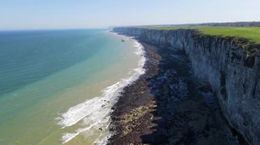 Etretat 'ın ikonik tebeşir kayalıkları ve turkuaz suları güneş ışığı altında parlayarak Normandiya' nın doğal güzelliğini ve huzurlu sahil şeridini gözler önüne seriyor..