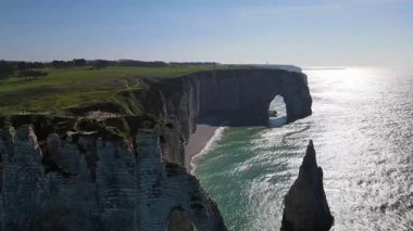 Etretat 'ın ikonik tebeşir kayalıkları ve turkuaz suları güneş ışığı altında parlayarak Normandiya' nın doğal güzelliğini ve huzurlu sahil şeridini gözler önüne seriyor..