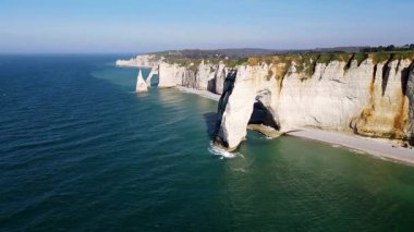 Etretat 'ın ikonik tebeşir kayalıkları ve turkuaz suları güneş ışığı altında parlayarak Normandiya' nın doğal güzelliğini ve huzurlu sahil şeridini gözler önüne seriyor..