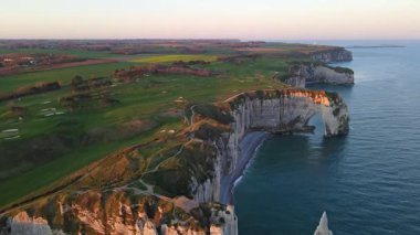 Etretat 'ın ikonik tebeşir kayalıkları ve turkuaz suları güneş ışığı altında parlayarak Normandiya' nın doğal güzelliğini ve huzurlu sahil şeridini gözler önüne seriyor..