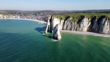 Etretat 'ın ikonik tebeşir kayalıkları ve turkuaz suları güneş ışığı altında parlayarak Normandiya' nın doğal güzelliğini ve huzurlu sahil şeridini gözler önüne seriyor..