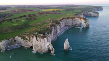 Etretat 'ın ikonik tebeşir kayalıkları ve turkuaz suları güneş ışığı altında parlayarak Normandiya' nın doğal güzelliğini ve huzurlu sahil şeridini gözler önüne seriyor..