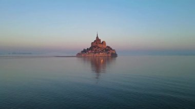 İkonik Mont Saint-Michel, kasvetli bir günde, ortaçağ köyü ve Normandiya kıyılarında sisli bir manastır ile yoğun bir siste ortaya çıkar.